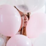 момиче заобиколена с розови балони