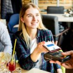 момиче плаща на ПОС терминал с телефона